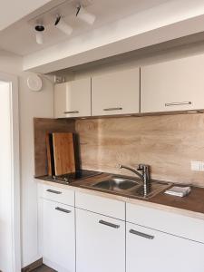 a kitchen with white cabinets and a sink at Alter Bahnhof Sichtigvor in Warstein +25 photos