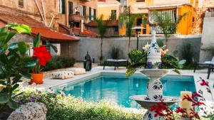 a fountain in a garden with a swimming pool at Palazzo Ricardi Chambres d'hotes in Imperia
