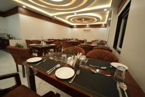 a dining room with tables and chairs and a ceiling at DN Resort Dharamshala in McLeod Ganj