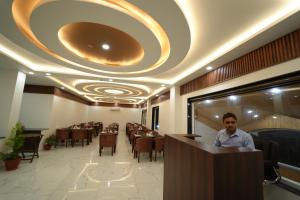 a man standing at a bar in a restaurant at DN Resort Dharamshala in McLeod Ganj +42 photos