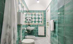 a green bathroom with a toilet and a sink at Authentic Oasis - Villa La Solara in Anacapri +46 photos