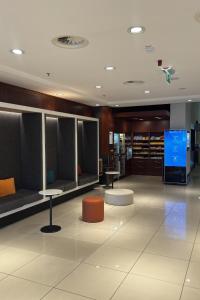 a lobby with benches and tables and a tv at Courtyard by Marriott Duesseldorf Hafen in Düsseldorf