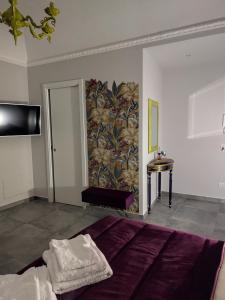 a bedroom with a bed and a wall with a wallpaper at Le stanze del Corso in Monreale