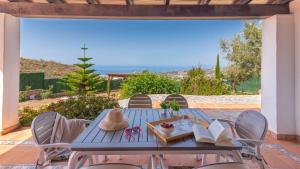 a blue table and chairs with a view of the ocean at Villa Infinity Torrox by Ruralidays in Torrox