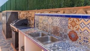 a kitchen with a sink and a tile counter top at Villa Infinity Torrox by Ruralidays in Torrox +24 photos