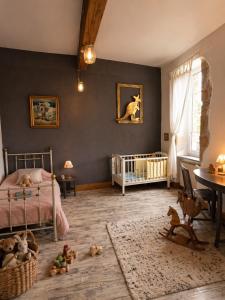 a bedroom with a bed and a crib and a table at Domaine du Prieuré avec Piscine Ancien Couvent & Presbytère in Carcassonne +32 photos