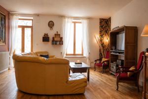 a living room with a couch and a table at Domaine du Prieuré avec Piscine Ancien Couvent & Presbytère in Carcassonne