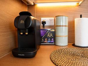 a coffee maker and a cup on a table at Beyond Hotel & Apartments in Burnley