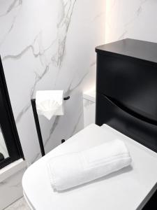 a bathroom with a black and white toilet with a towel at Beyond Hotel & Apartments in Burnley