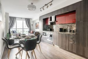 a kitchen and dining room with a table and chairs at Stylish 1BR plus Den Suite with Parking, Sleeps 4) in Toronto