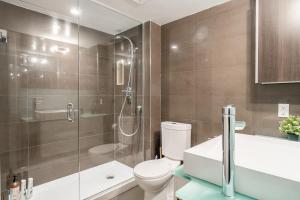 a bathroom with a toilet and a glass shower at Stylish 1BR plus Den Suite with Parking, Sleeps 4) in Toronto +14 photos