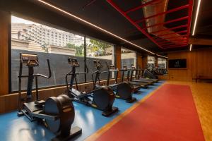 a gym with treadmills and ellipticals in a row at Taj Krishna in Hyderabad