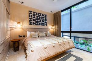 a bedroom with a large bed and a large window at Luxury Beachfront 3BR Appartment in Tulum +21 photos