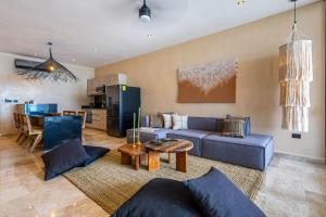 a living room with a blue couch and a table at Luxury Beachfront 3BR Appartment in Tulum
