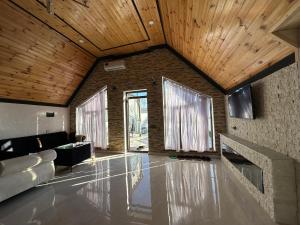 a living room with a stone floor and wooden ceilings at Firepalace Gabala in Gabala