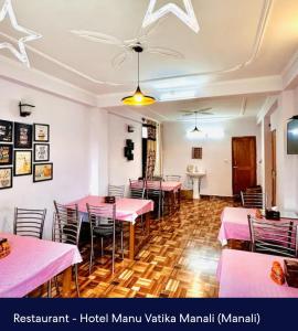 a dining room with pink tables and chairs at Hotel Royal Selection in Manāli