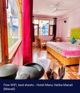 a bedroom with a bed and a table and chairs at Hotel Royal Selection in Manāli