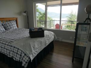 a bedroom with a bed with a suitcase on it at Howe Sound View in Bowen Island