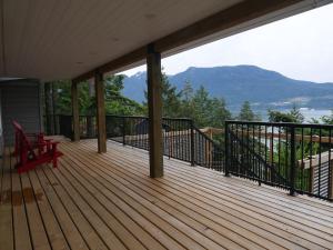 a deck with a bench and a view of the mountains at Howe Sound View in Bowen Island