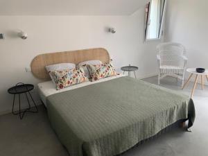 a bedroom with a large bed with two tables and chairs at Villa des Ponteils in Moliets-et-Maa +13 photos
