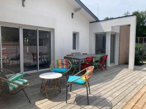 a deck with chairs and a table and a table and chairs at Villa des Ponteils in Moliets-et-Maa
