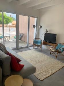 a living room with a couch and a television at Villa des Ponteils in Moliets-et-Maa