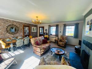 a living room filled with furniture and a table at Braehead Cottage in Glencoe