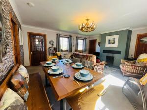 a living room with a wooden table and chairs at Braehead Cottage in Glencoe