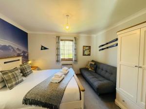 a bedroom with a large bed and a couch at Braehead Cottage in Glencoe