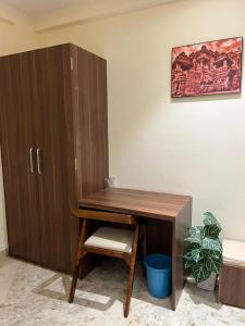 a wooden desk with a chair next to a cabinet at Hotel Ashoka Resort in Ellora