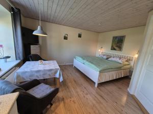ein Schlafzimmer mit einem Bett, einem Tisch und einer Couch in der Unterkunft Postgaarden Frøslev in Padborg