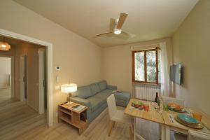 a living room with a couch and a table at Olive Garden Garda - pool & view in Moniga