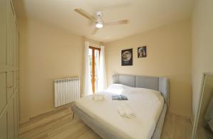 a bedroom with a bed with a ceiling fan at Olive Garden Garda - pool & view in Moniga +30 photos