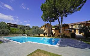 a swimming pool in front of a house at Olive Garden Garda - pool & view in Moniga
