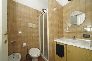 a bathroom with a toilet and a sink and a mirror at Casa vacanza Iris in Toscolano Maderno +21 photos