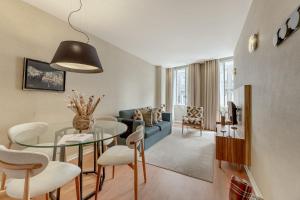 a living room with a glass table and a blue couch at Casas do Porto - Ribeira Apartments in Porto