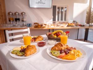a table with plates of pastries and orange juice at Hotel Four Islands in Ksamil