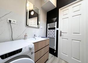 a bathroom with a toilet and a sink and a white door at Maison 2 chambres avec bureau - Proche gare in Saint-Omer