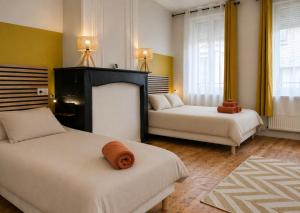 a hotel room with two beds and two windows at Maison 2 chambres avec bureau - Proche gare in Saint-Omer +18 photos