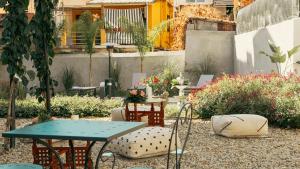 a patio with tables and chairs in a garden at Palazzo Ricardi Chambres d'hotes in Imperia