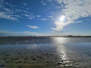 a large body of water with the sun in the sky at La Colline - Pont-Hébert - com - Grand Parking gratuit, De 1 à 4 personnes, Tout équipé, Netflix, Amazon Prime Gratuits et Illimités, Matelas Emma, Lave Linge, Vue sur la Vallée, RDC in Pont-Hébert