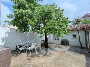 a patio with a table and chairs under a tree at Casa Patio Zamora in Zamora