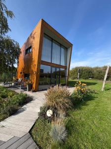 a wooden house with glass windows in a garden at Casitas Wijchen - Nijmegen in Wijchen