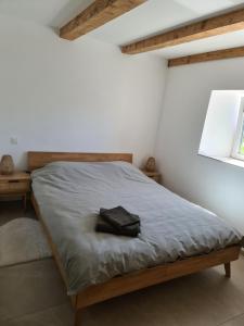 a bedroom with a bed with a black bag on it at Au petit nid in Vilars