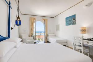 a white bedroom with a bed and a desk and chairs at Phi Hotel Sighientu in Capitana +72 photos