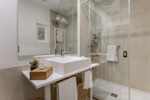 a white bathroom with a sink and a shower at Casas do Porto - Ribeira Apartments in Porto +142 photos