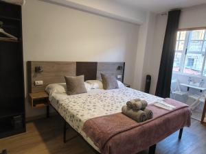 a bedroom with a bed with two towels on it at Pensión Casa Douro in Santiago de Compostela