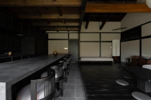 a room with a bar with chairs and a bed at MUSUBI Hakone in Sengokuhara