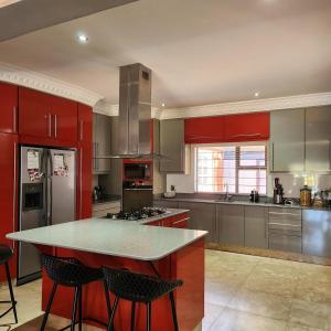 a large kitchen with red cabinets and a counter top at Ntobongwana in Pinetown