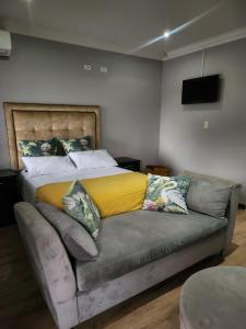 a bed with a yellow blanket on top of a couch at Ntobongwana in Pinetown